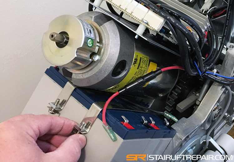 Service tech replacing stairlift batteries